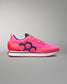 Pink sneaker with black hexagonal design on a gray background