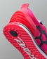 Close-up of a pink and red running shoe with a textured sole on a gray background