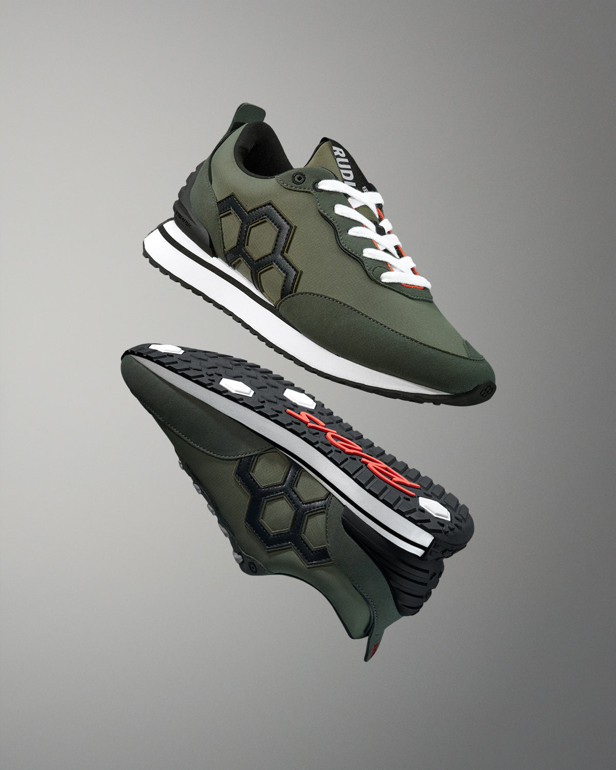 Green and black athletic shoes with white laces on a gray background