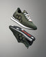 Green and black athletic shoes with white laces on a gray background