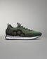 Green sneaker with black hexagonal pattern on a gray background