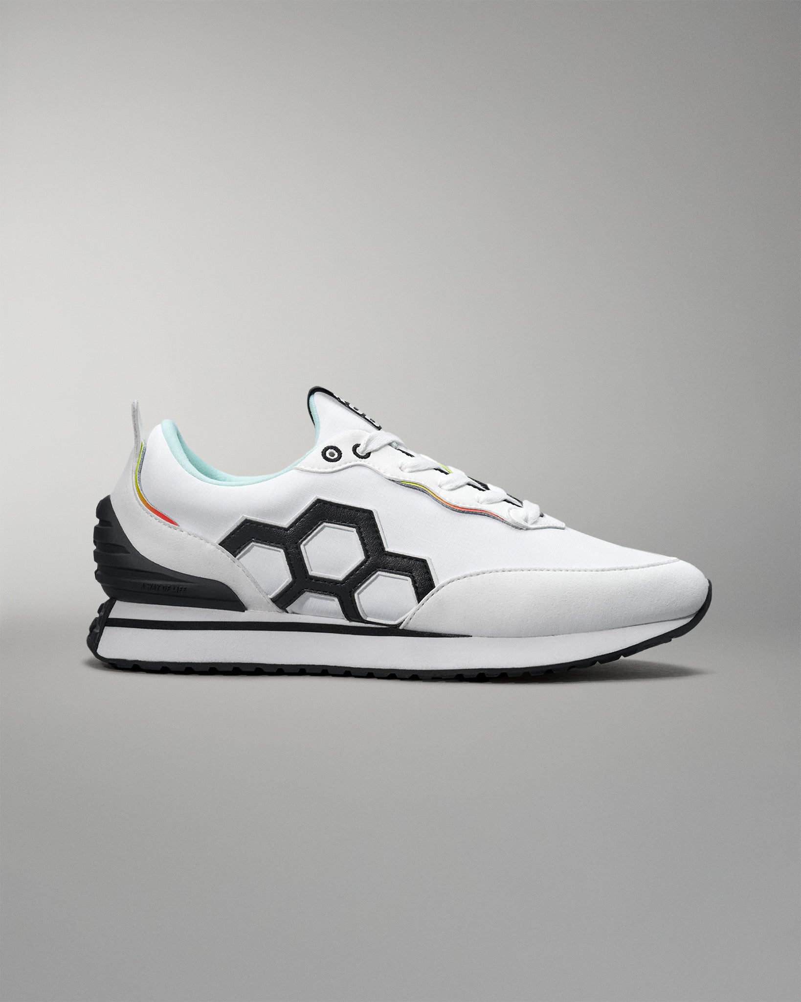 White sneaker with black geometric design on a gray background