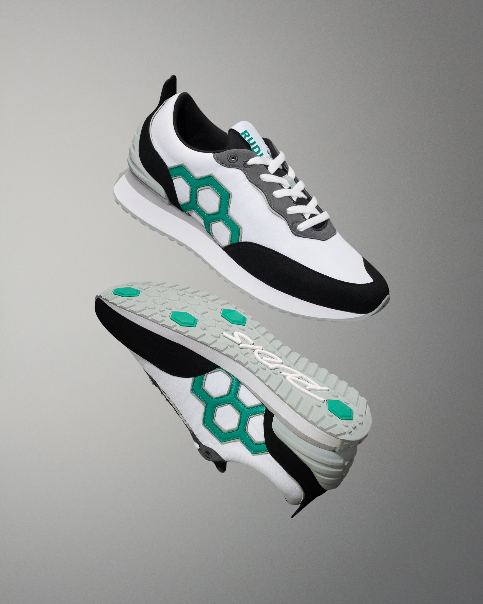 White sneakers with black and green accents on a gray background