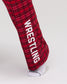 Close-up of RUDIS Hex Flannel Lounge Pants in Red and black plaid, highlighting the large white WRESTLING lettering printed down the lower leg. Copy Alt Text