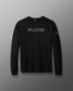 A black long-sleeve performance shirt with 'RUDIS' printed in gray across the chest and a small logo on the right sleeve, displayed against a dark gray gradient background.