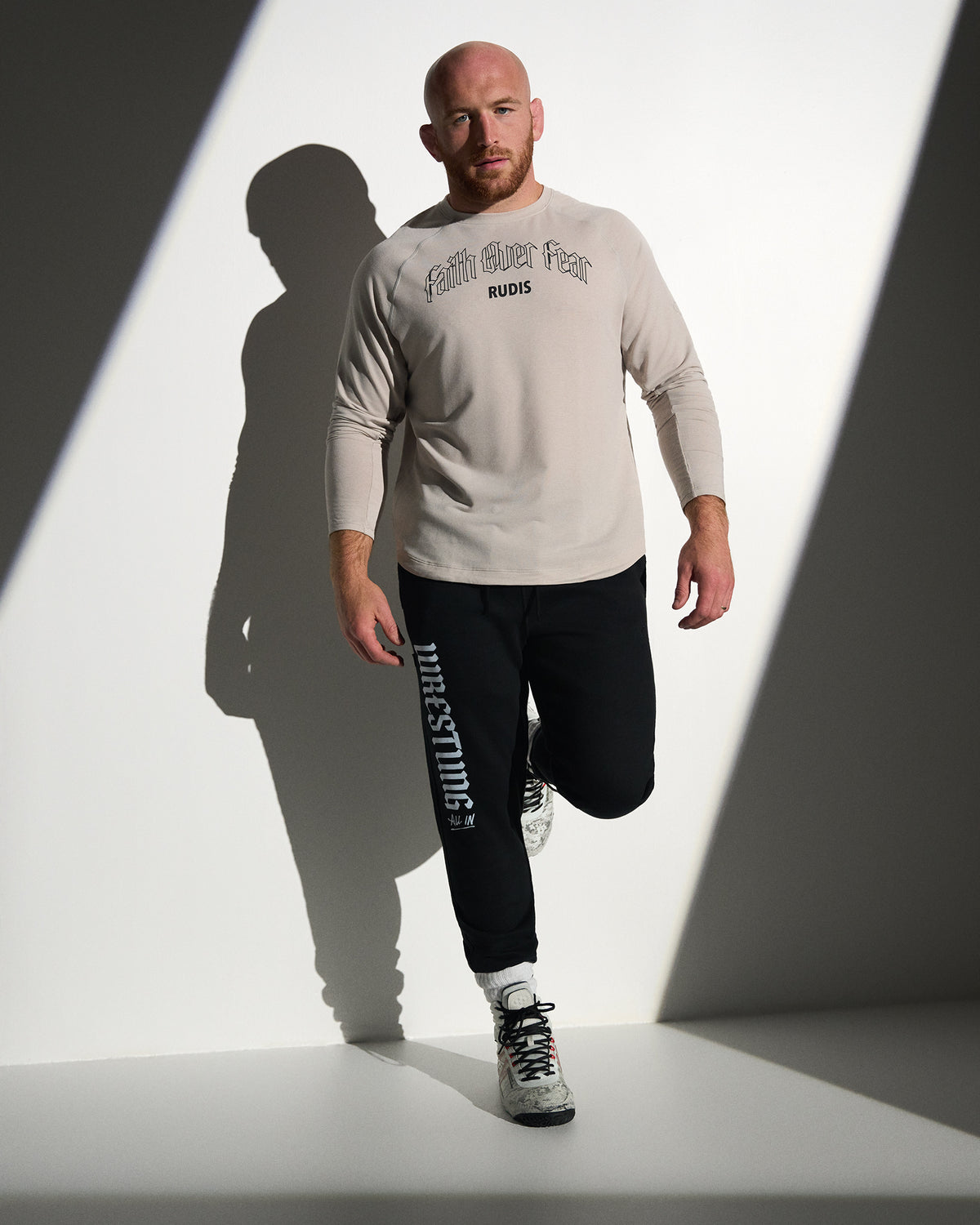 RUDIS Faith Over Fear Tech Thermal in Bone styled with black Gothic Wrestling Titan Heavyweight Joggers, featuring breathable performance fabric, gothic-inspired graphics, and a versatile athletic fit.