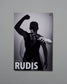 Poster of a person with one arm raised, wearing a black outfit, on a gray background with 'RUDIS' branding.