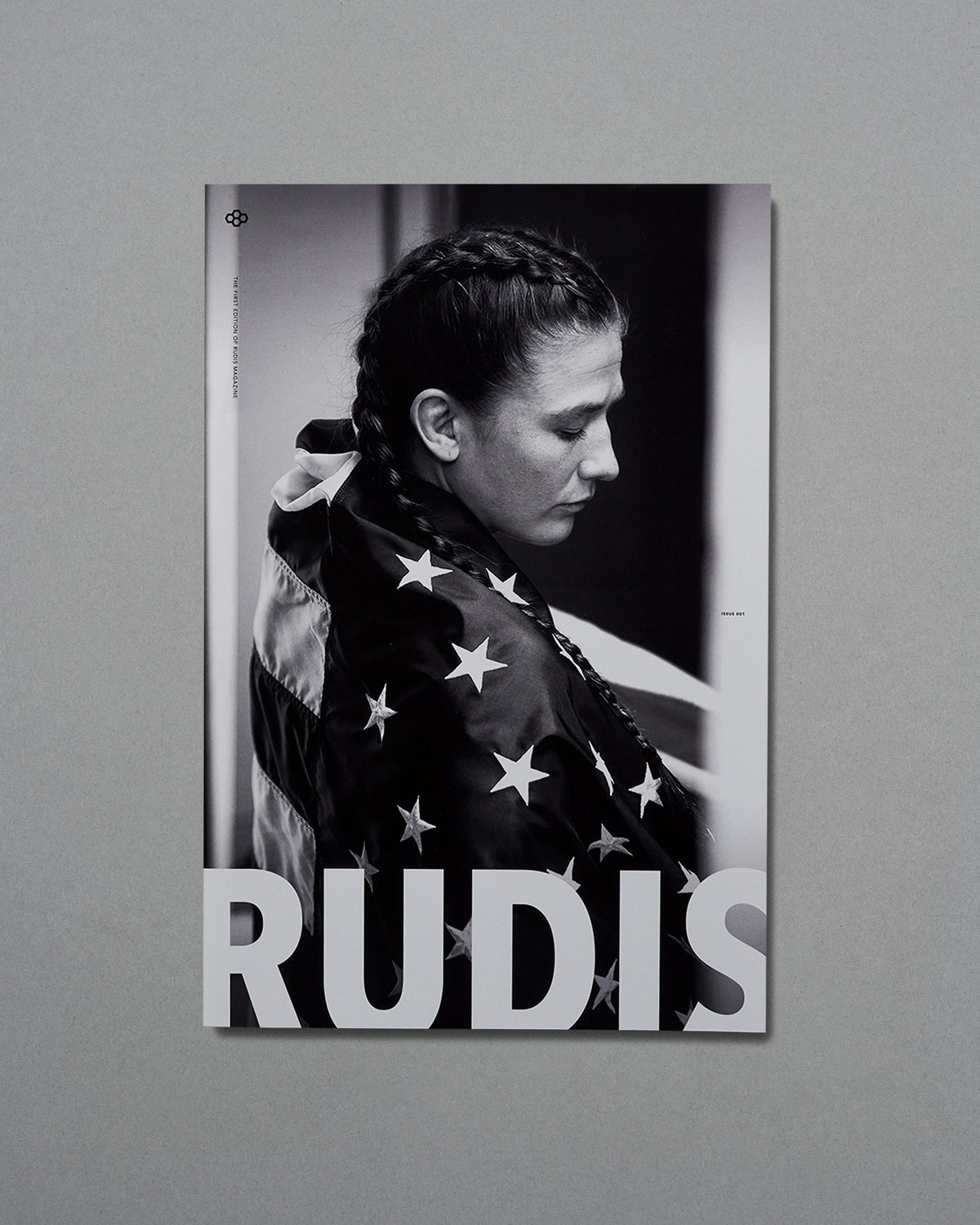 Poster of a person wrapped in an American flag with 'RUDIS' branding on a gray background