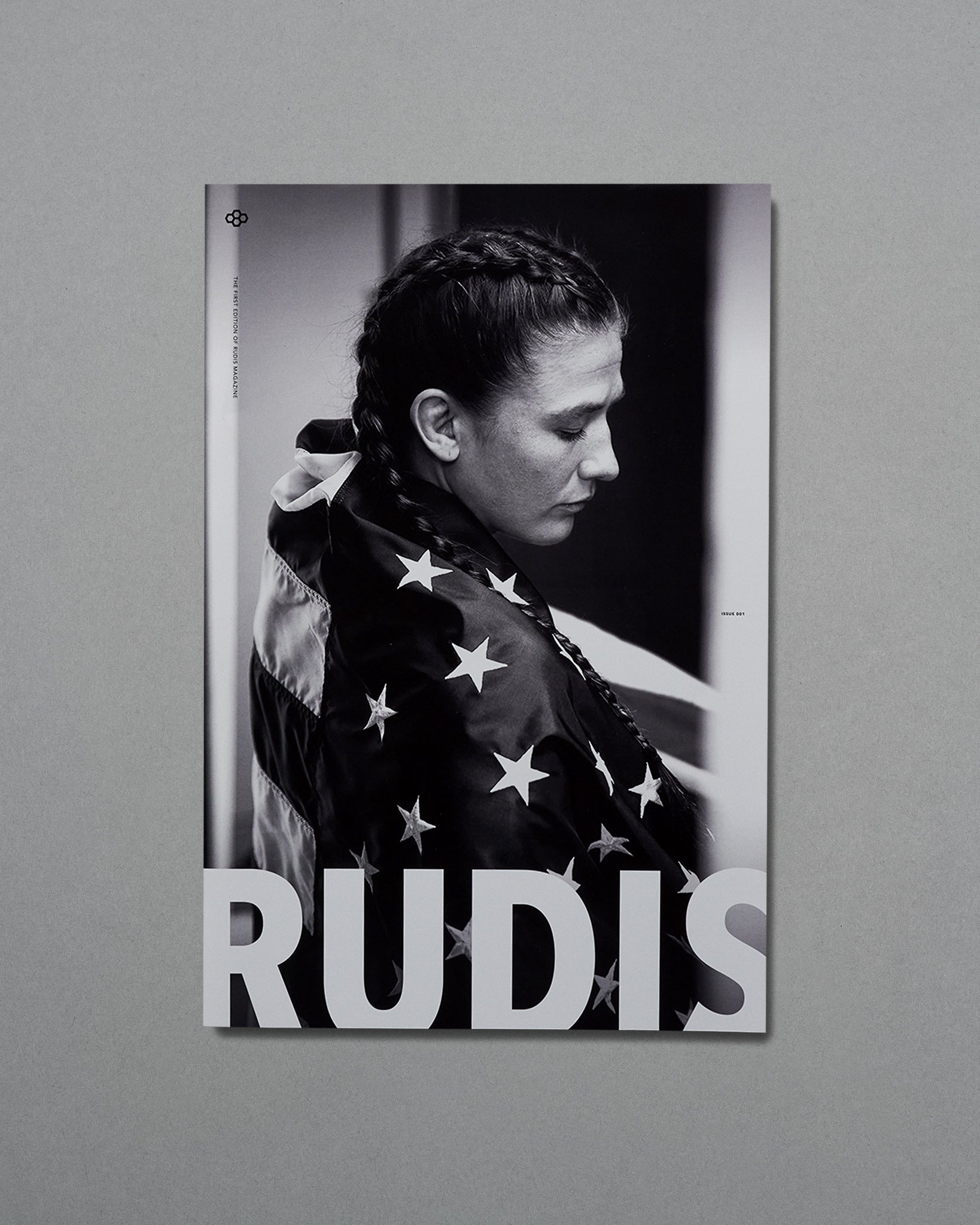 Poster of a person wrapped in an American flag with 'RUDIS' branding on a gray background