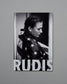 Poster of a person wrapped in an American flag with 'RUDIS' branding on a gray background