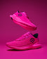 Pink running shoes with black logo on a pink background - wrestling training shoes