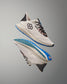 White running shoes with blue soles on a gray background