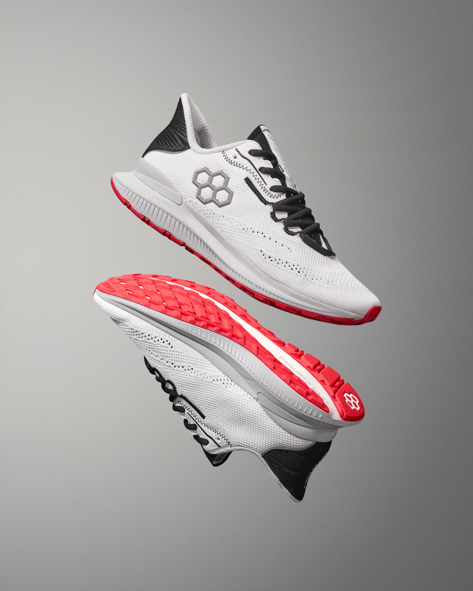 White running shoes with red soles on a gray background