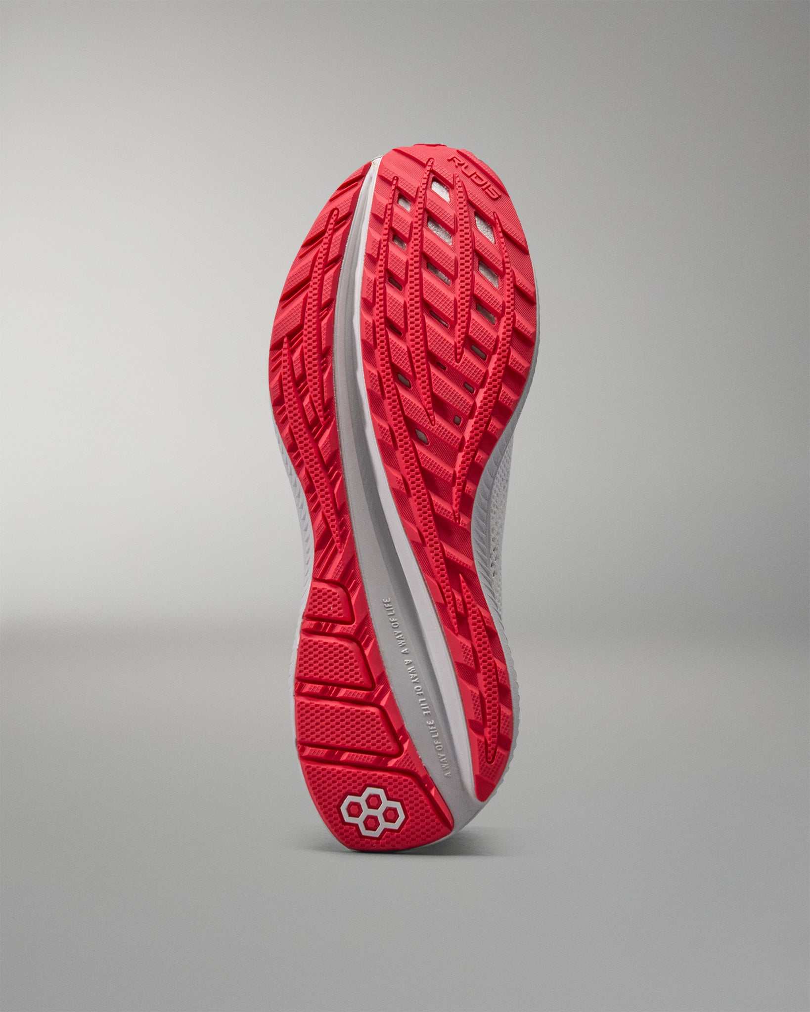 Red and white training shoe sole on a gray background