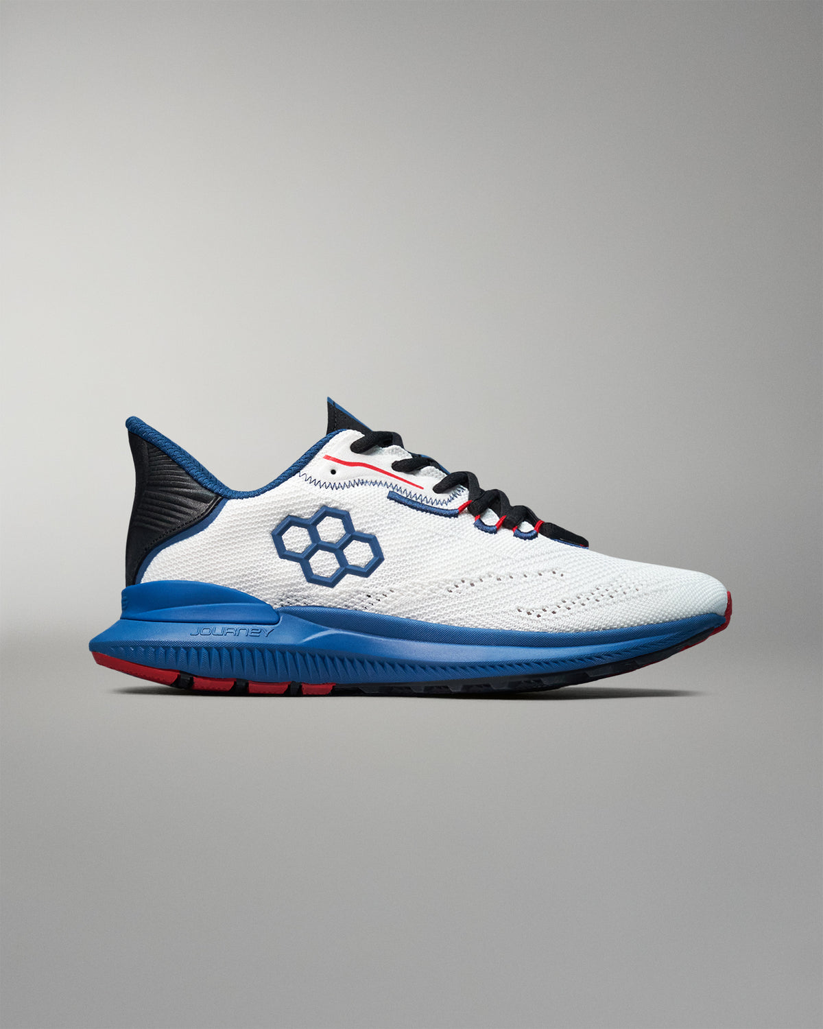 Side view of a white RUDIS training shoe featuring a blue hexagon logo, black and red laces, blue midsole, and black heel support. Displayed on a neutral gray background.