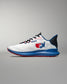 Side view of a white RUDIS training shoe with blue and red detailing, featuring the USA Wrestling logo on the heel, black laces, and a blue midsole with red tread, displayed against a neutral gray background.