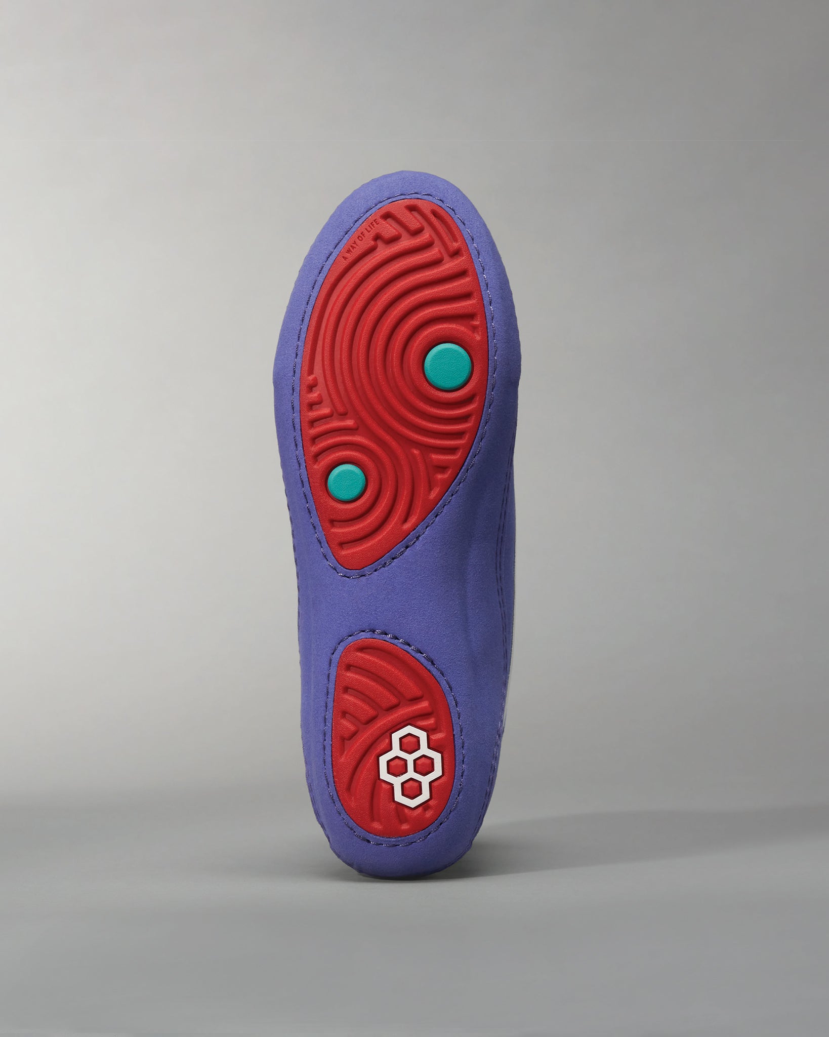 A vibrant purple shoe sole featuring red accents and textured grips designed for optimal traction
