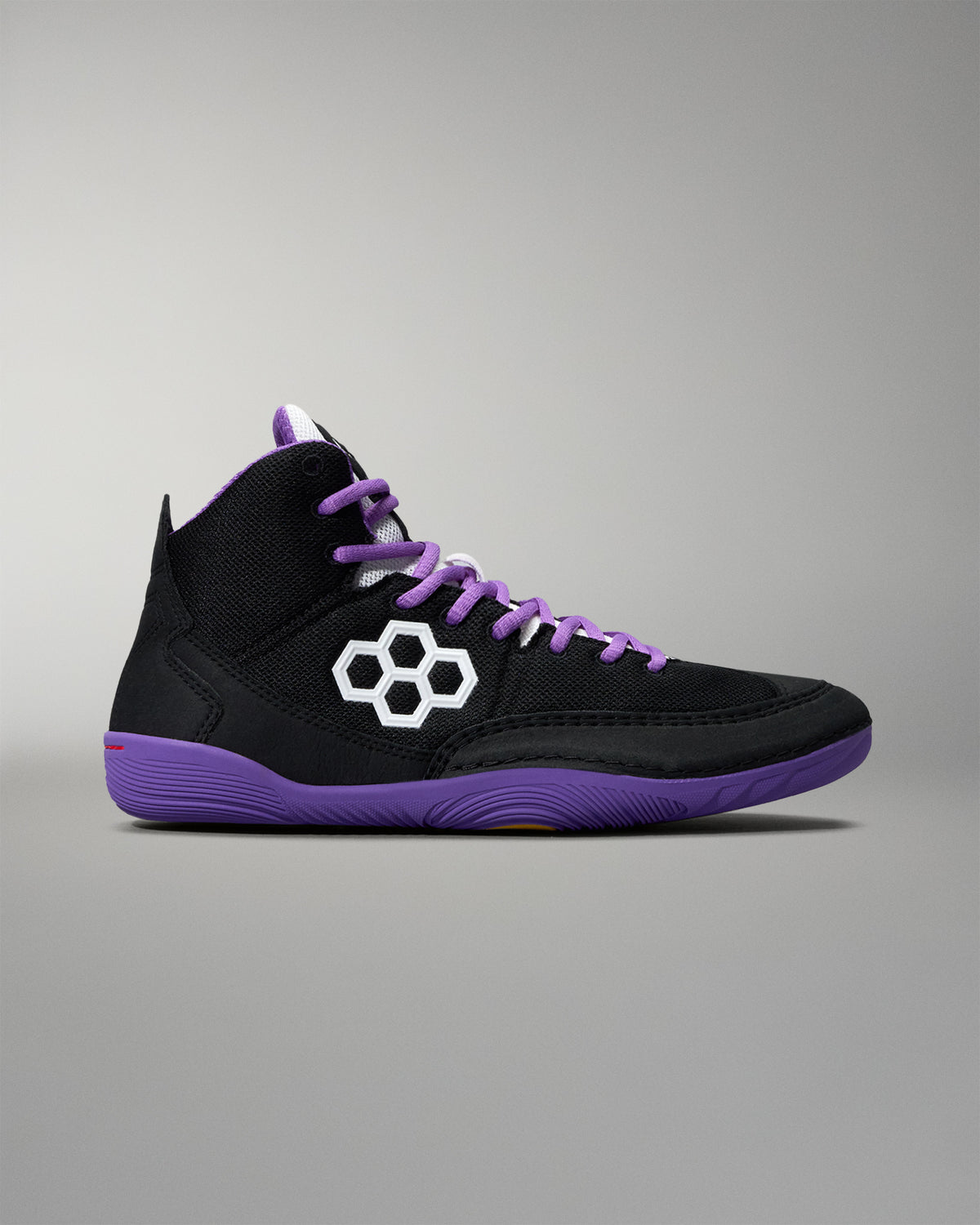 Black high-top sneaker with purple accents and a white logo on a gray background