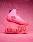 Pink wrestling shoes with black text and logo on a pink background