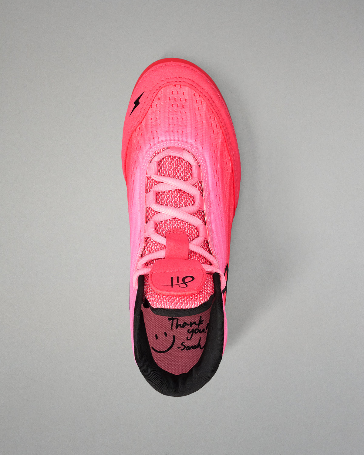 Pink wrestling shoe with black sole on a gray background