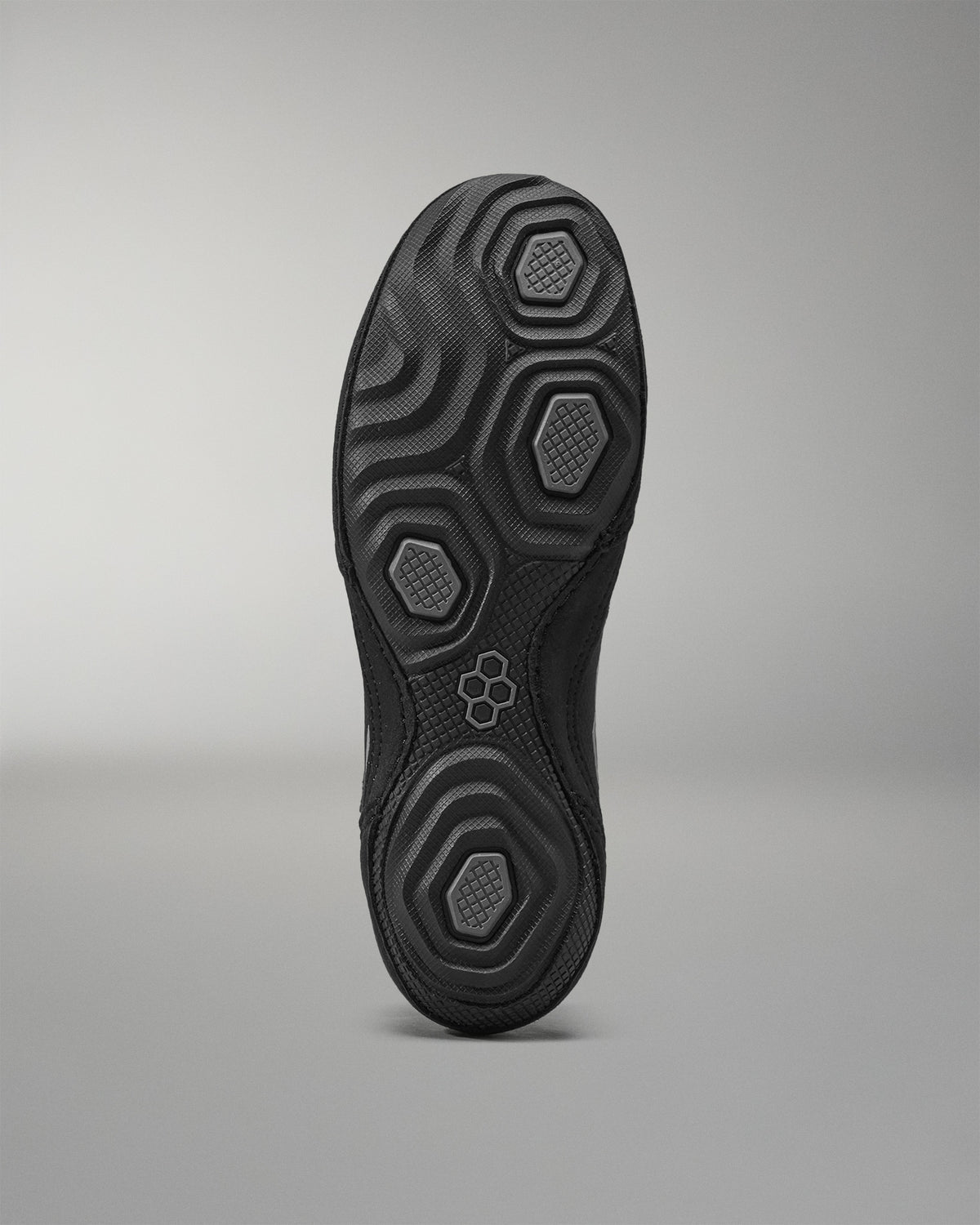 Black Wrestling shoe sole with textured pattern on a gray background