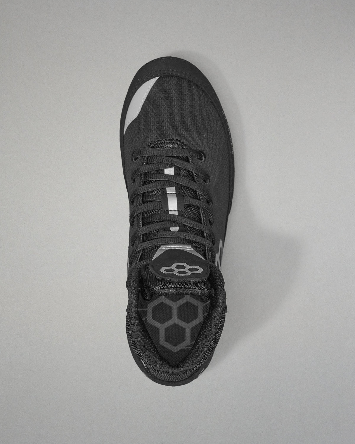 Black Wrestling shoe with a unique sole design on a gray background