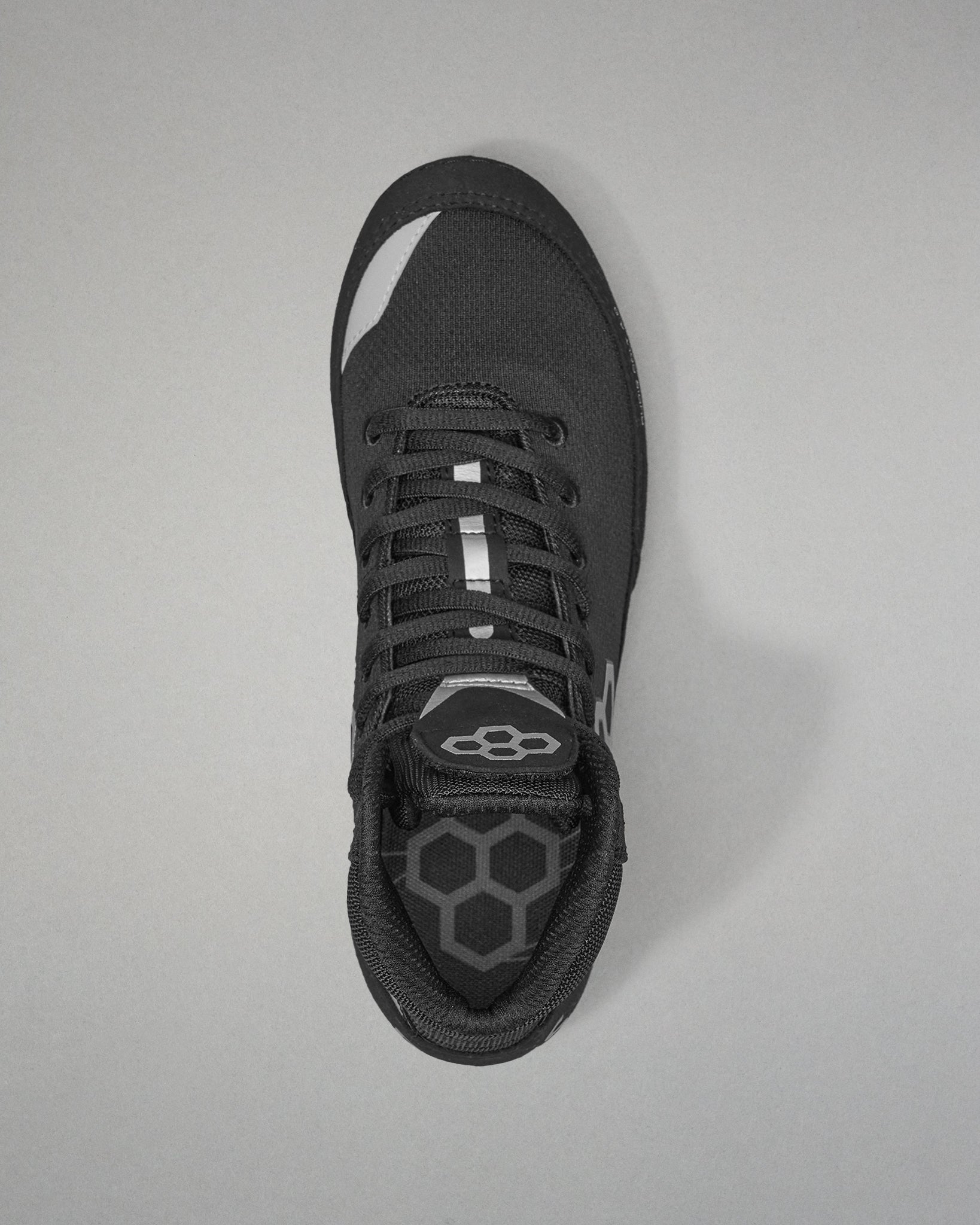 Black Wrestling shoe with a unique sole design on a gray background