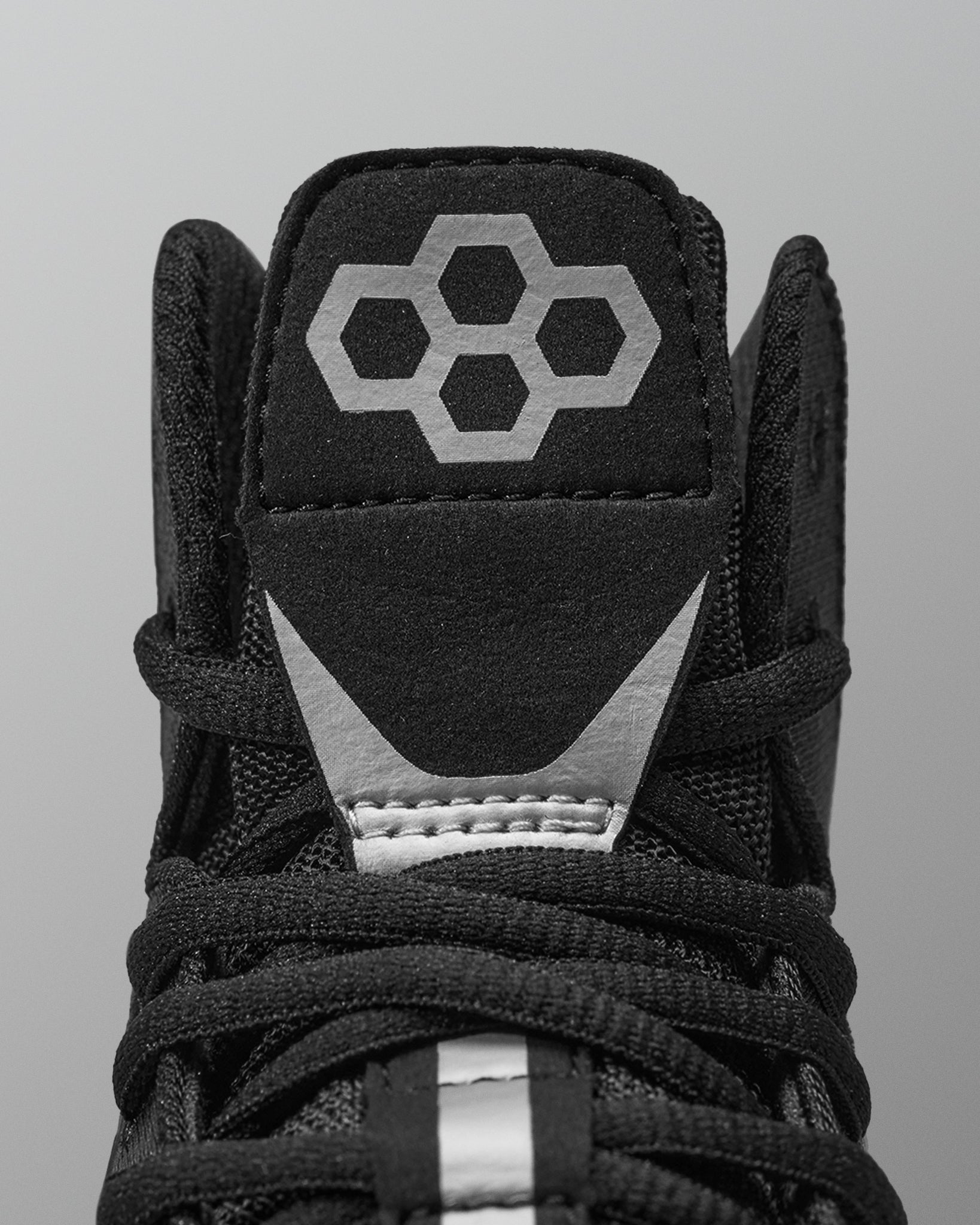 Black Wrestling shoe with a geometric logo on a gray background