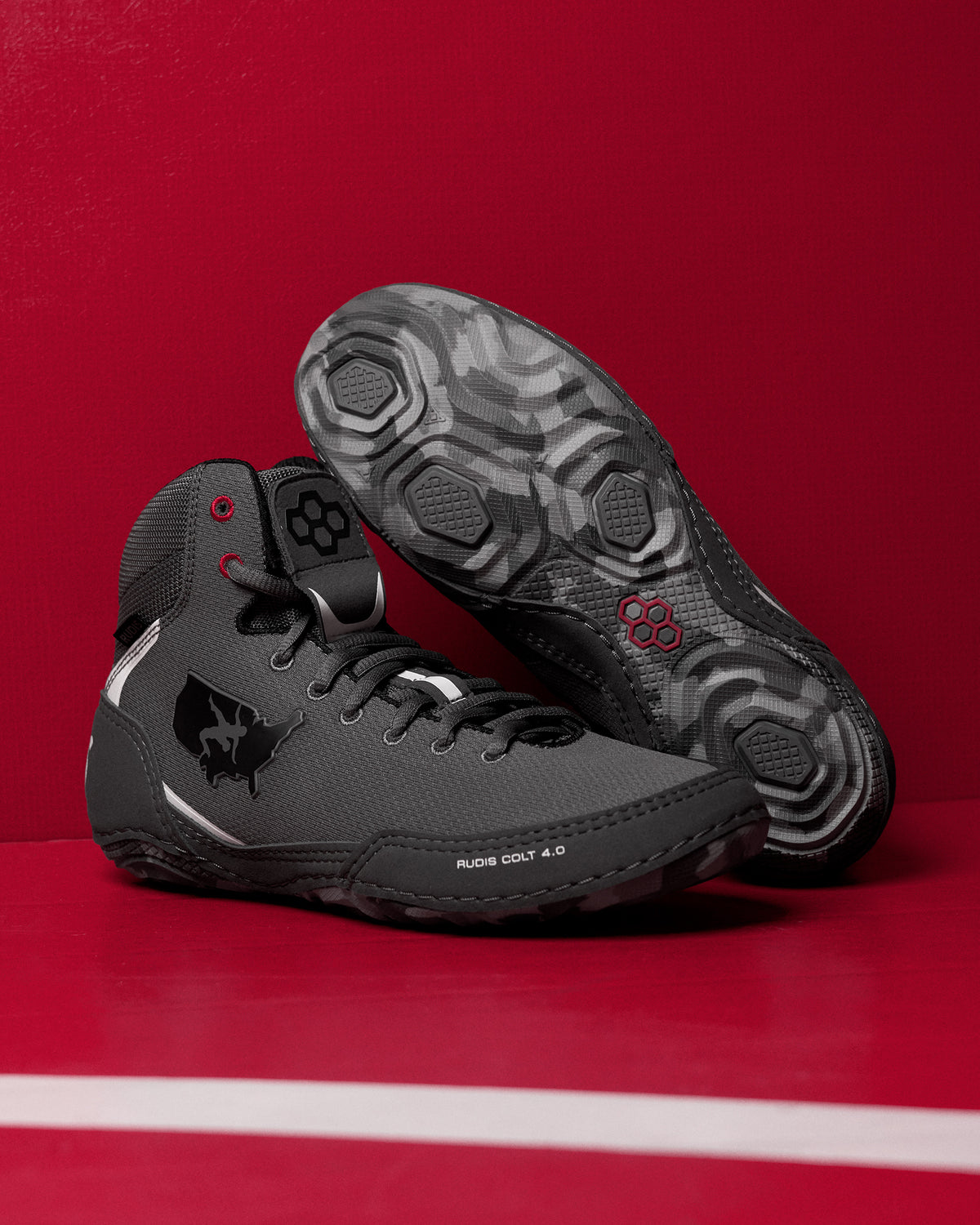 Black wrestling shoes on a red background
