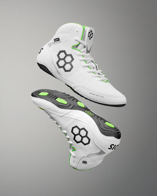 White wrestling shoes with black and green accents on a gray background