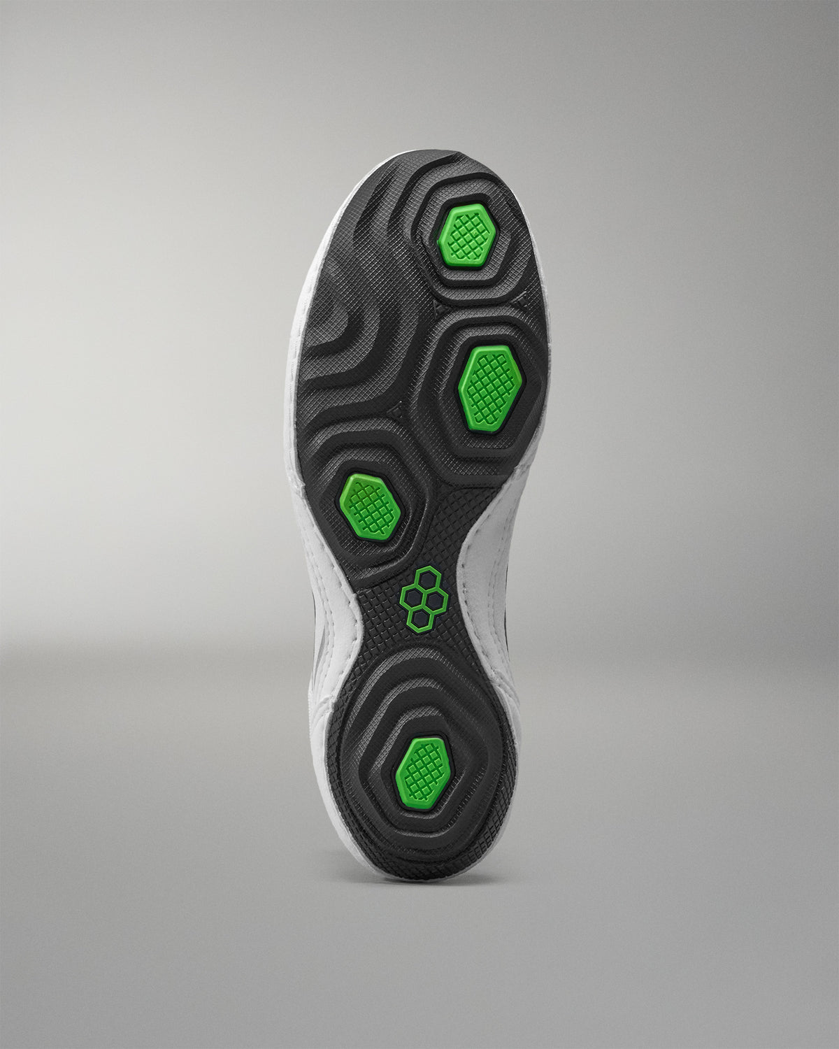 Close-up of a wrestling shoes sole with green hexagonal patterns on a gray background