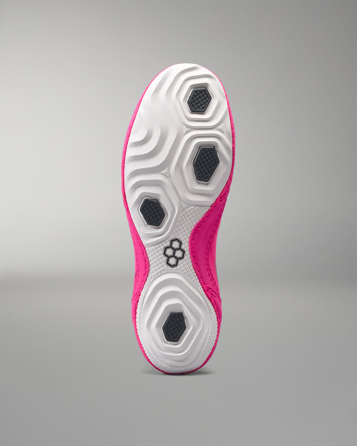 Close-up of a pink and white athletic shoe sole on a gray background
