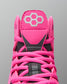 Close-up of a pink sports shoe with a brand logo on a gray background