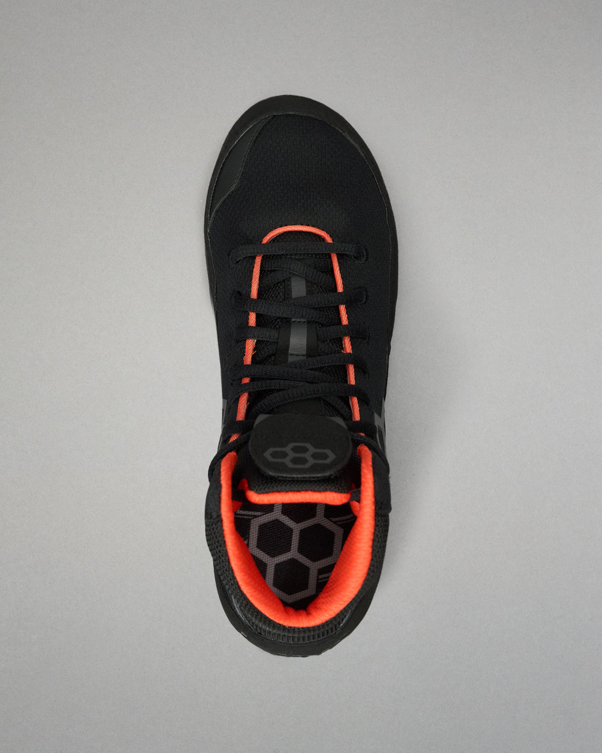 A black Wrestling shoe with vibrant orange accents, shown from a top-down view on a neutral gray background.