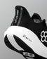 Black and white athletic shoe with branding on a gray background