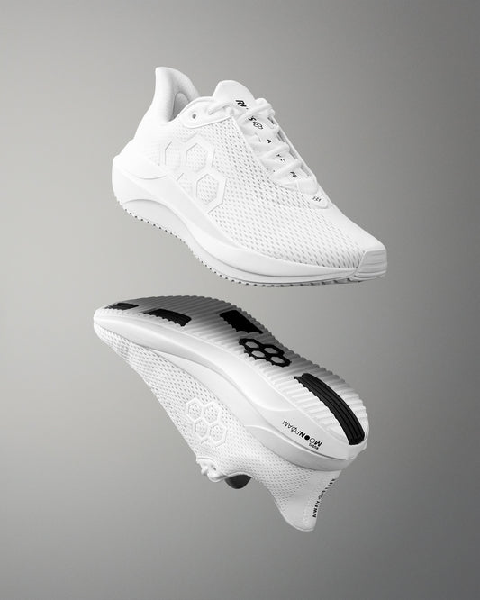 White athletic shoe with brand logo on a gray background