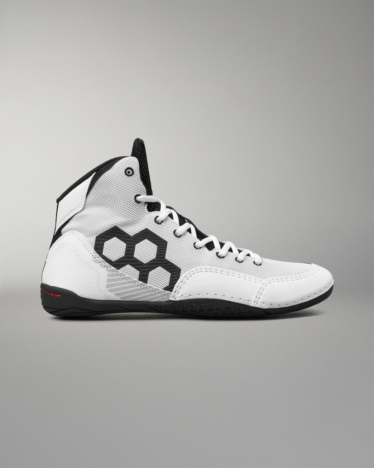 A white high-top wrestling shoe with black accents, featuring a large black geometric pattern on the side, white laces, and a black outsole, shown against a neutral gray background.