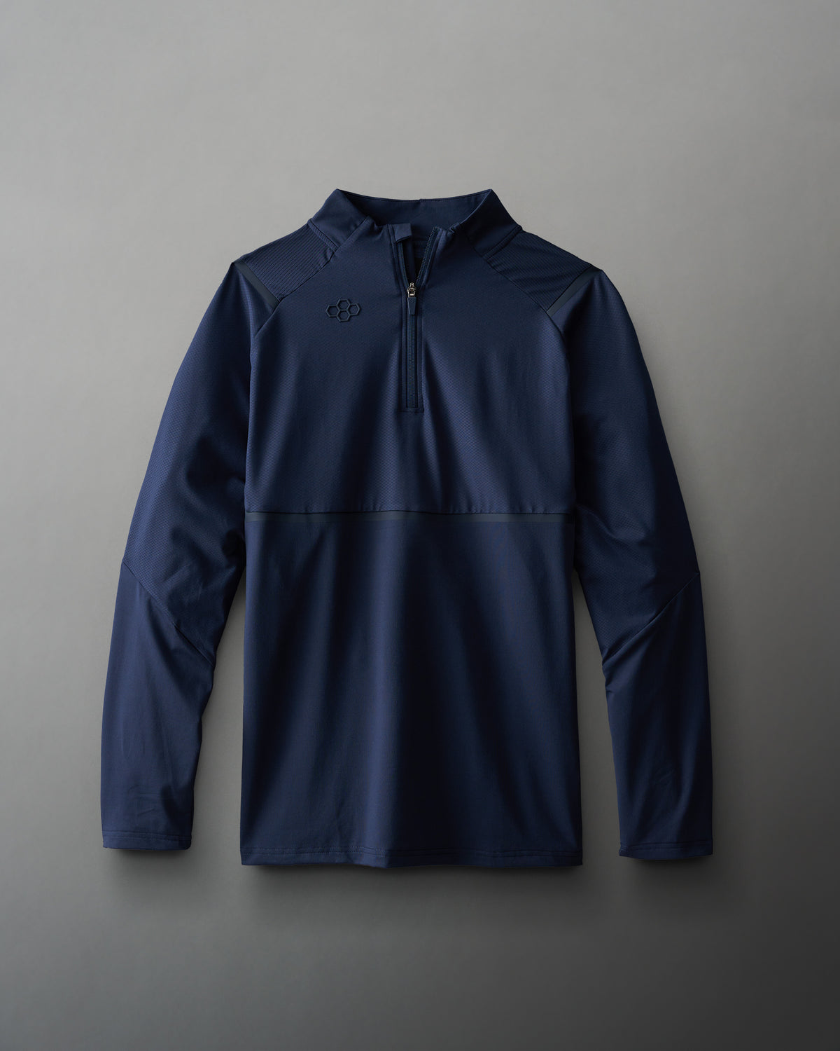 A navy blue long-sleeve quarter-zip pullover jacket with a subtle embroidered logo on the left chest, displayed flat against a neutral gray background.