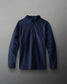 A navy blue long-sleeve quarter-zip pullover jacket with a subtle embroidered logo on the left chest, displayed flat against a neutral gray background.