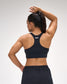 Person wearing a black sports bra with 'Ruds' branding on a plain background