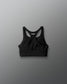 Black sports bra with brand logo on a gray background