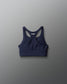 Navy blue sports bra with 'RUDIS' branding on a gray background