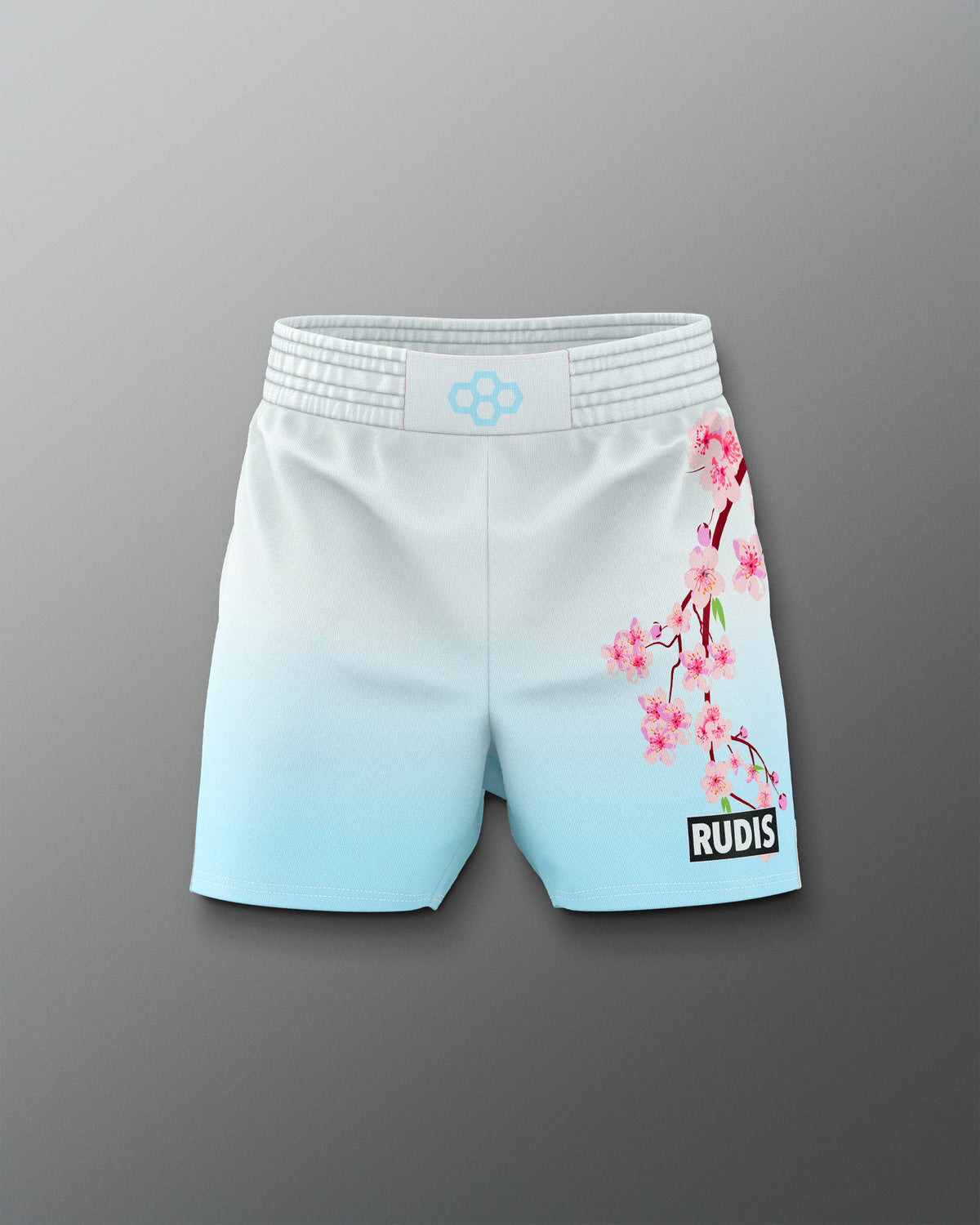White shorts with cherry blossom design and 'RUDIS' branding on a gray background
