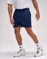 Person wearing navy shorts and white sneakers on a plain background