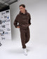 Person wearing a brown tracksuit with 'RUDIS' branding in a studio setting.