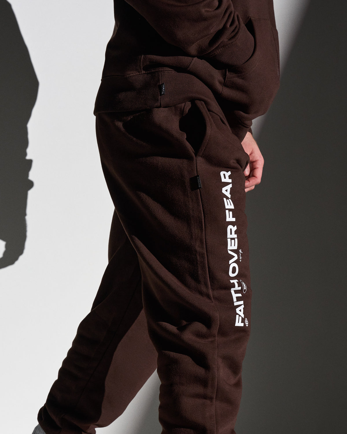 Brown sweatpants with 'Faith Over Fear' text on a plain background