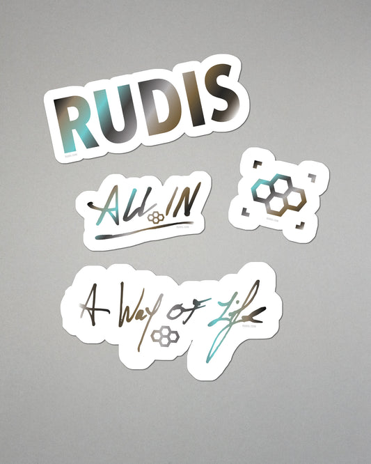 Four stickers with 'RUDIS', 'All In', and 'A Way of Life' text on a gray background