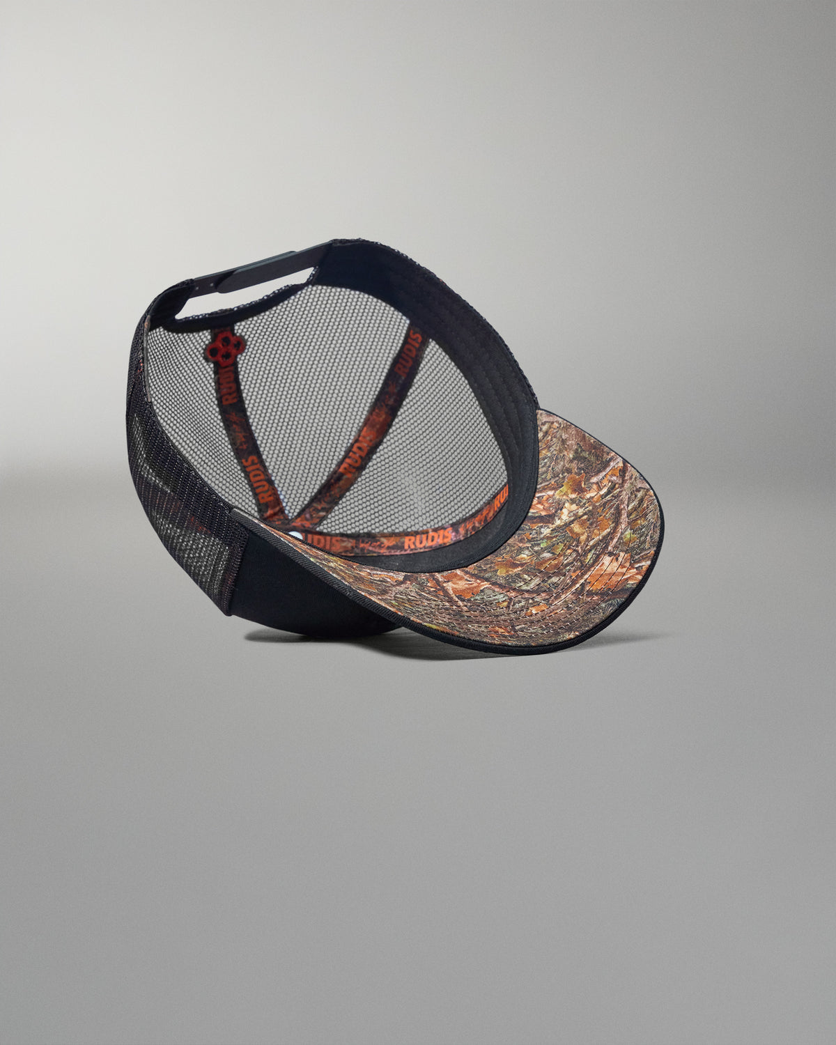 Cap with camouflage front and black mesh back on a gray background