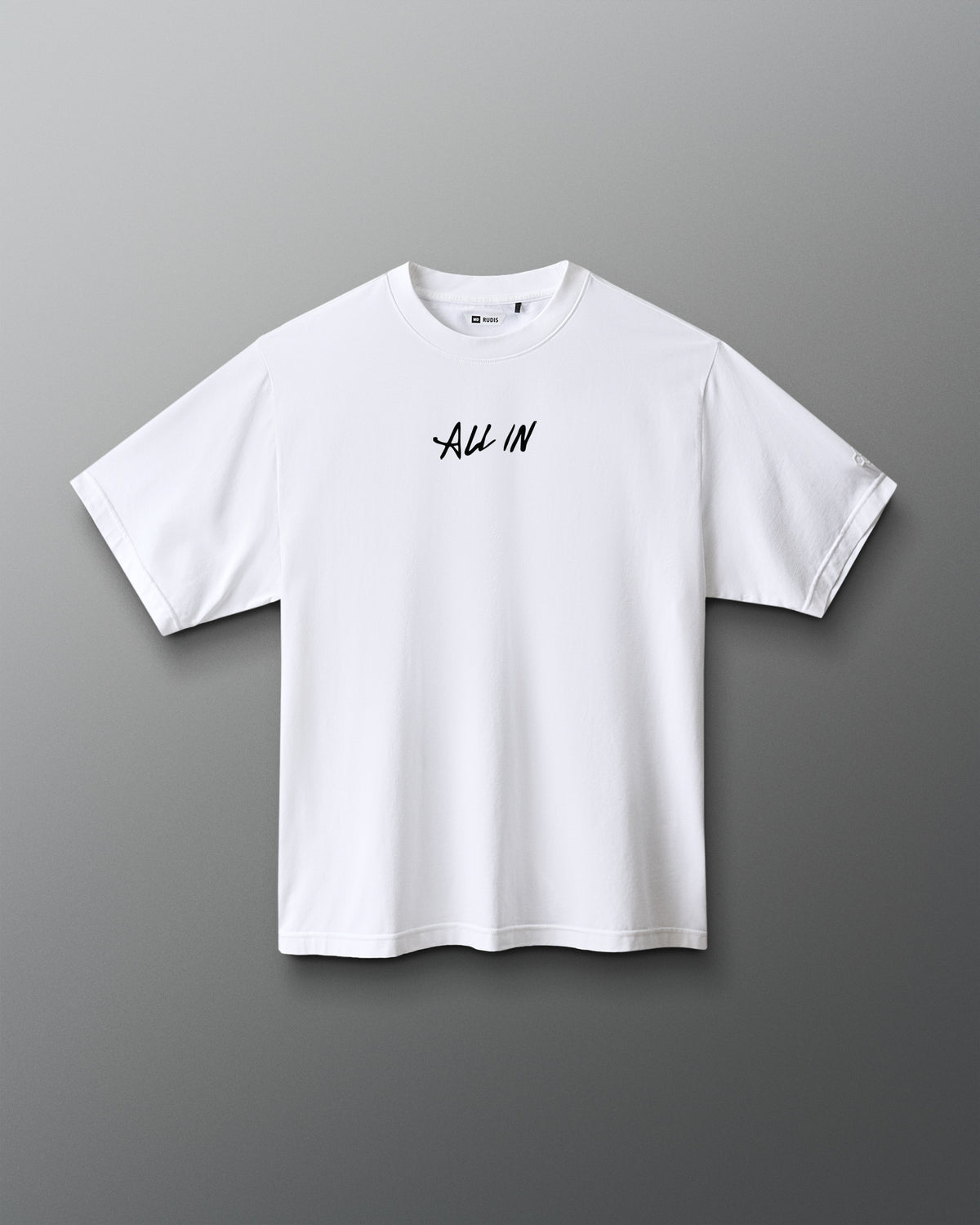 A white short-sleeve crewneck t-shirt with the words 'ALL IN' printed in black script across the chest, displayed against a dark gray gradient background.