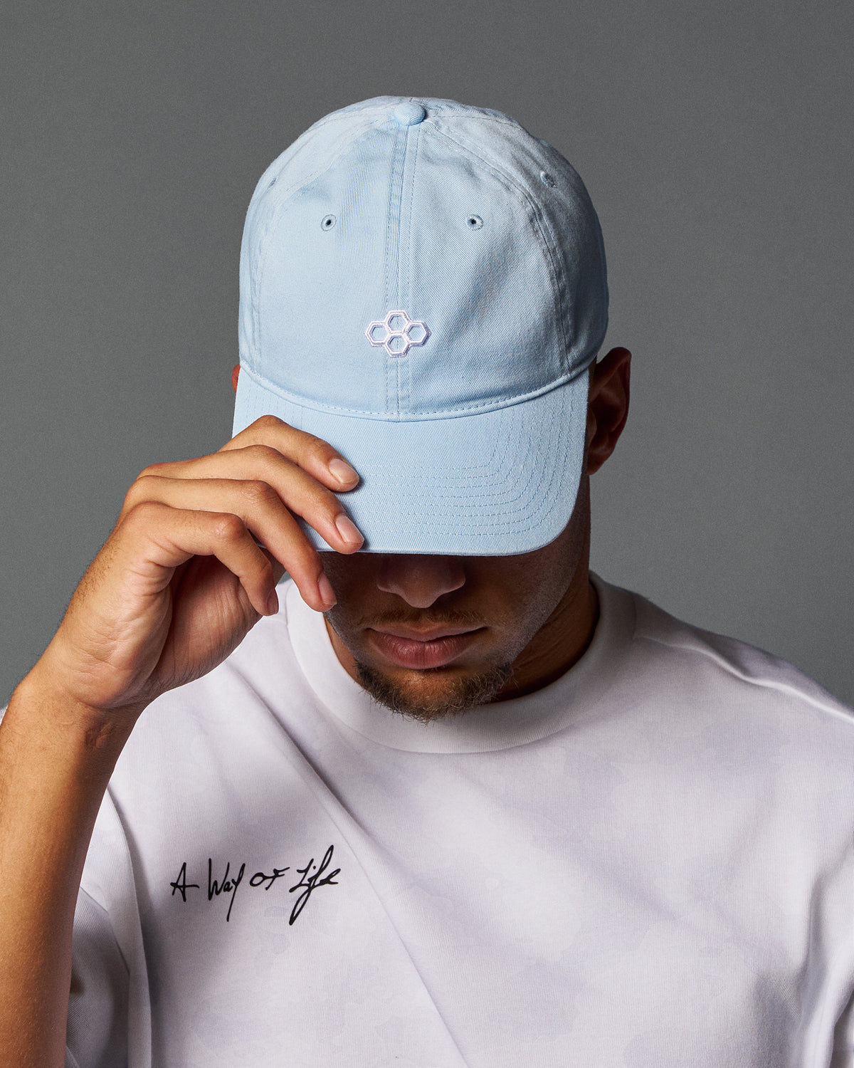 Person wearing a light blue cap and white t-shirt with text on a gray background